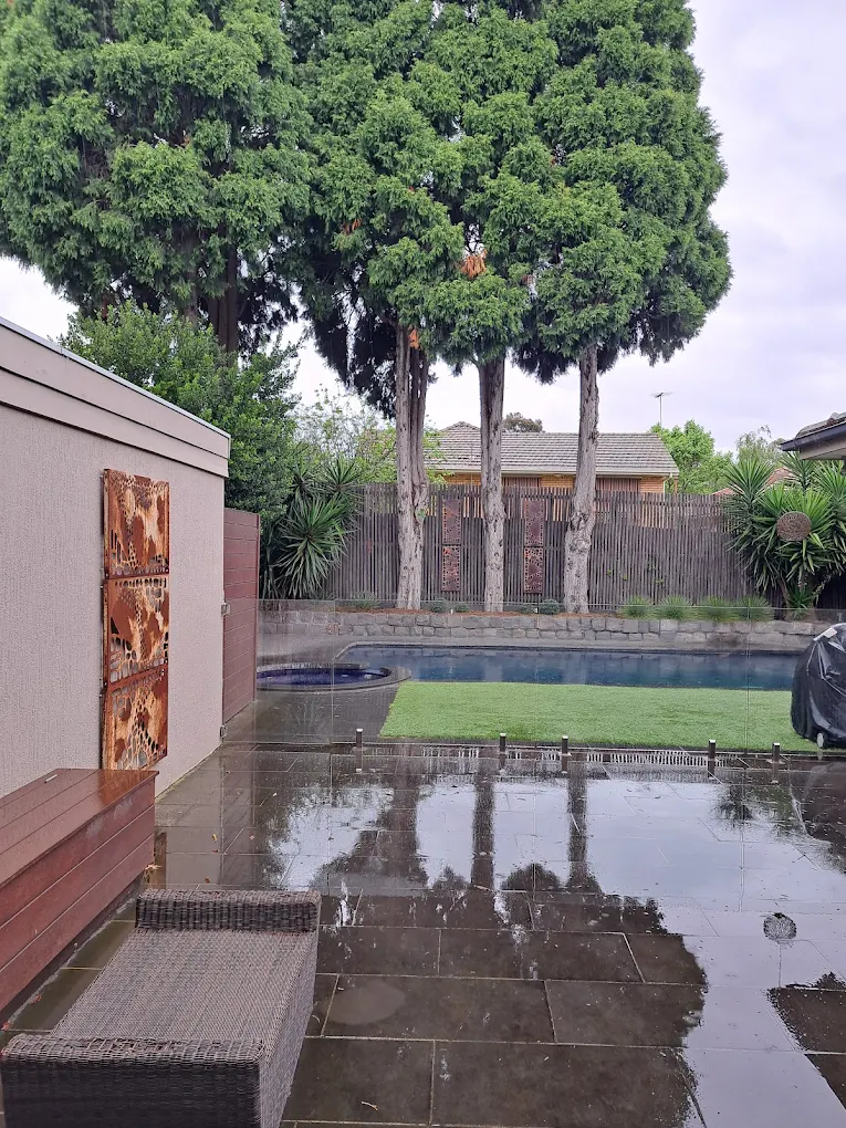 Boundary fence beside a Melbourne backyard pool being inspected for compliance.